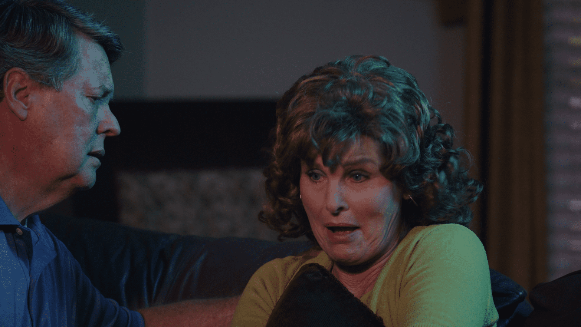 A woman sitting on the couch looking at something. A woman sitting on the couch looking at something.