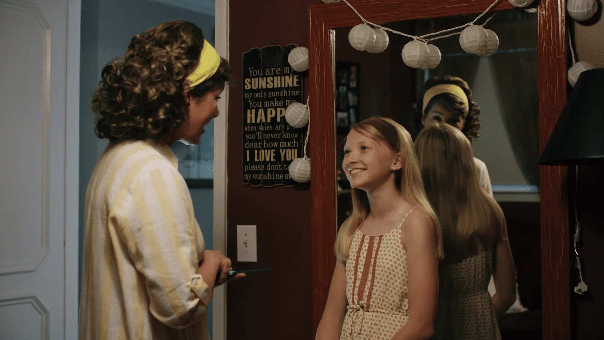 A woman and girl in front of a mirror. A woman and girl in front of a mirror.