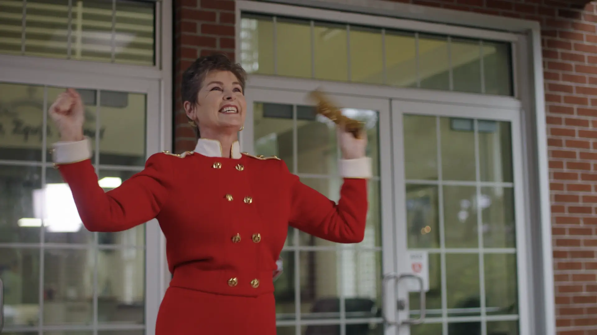 A woman in red dress holding something up to her face. A woman in red dress holding something up to her face.